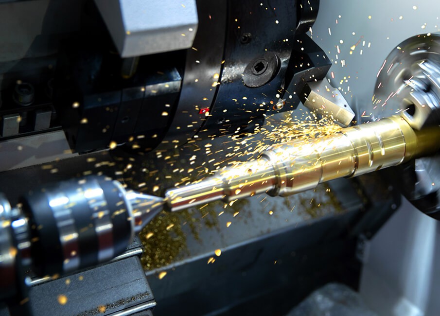 CNC lathe turning a brass shaft between centers